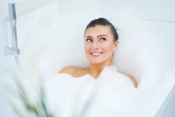 Jeune belle femme brune ayant bain dans la baignoire — Photo