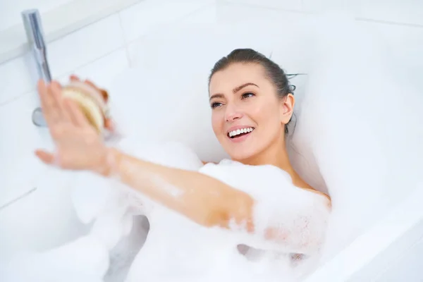 Genç, güzel esmer kadın küvette banyo yapıyor. — Stok fotoğraf