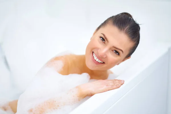 Ung trevlig brunett kvinna som badar i badkar — Stockfoto