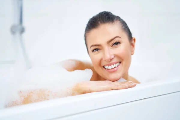 욕조에서 목욕하고 있는 젊고 아름다운 갈색 머리 여인 — 스톡 사진