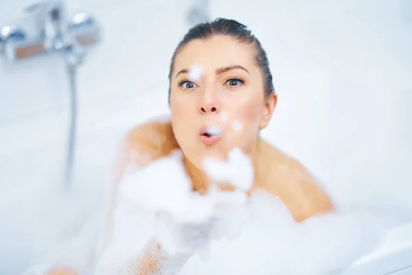 Jovem mulher morena agradável tendo banho na banheira — Fotografia de Stock