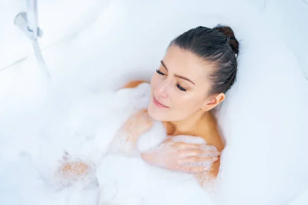 Młoda miła brunetka kobieta mając kąpiel w wannie — Zdjęcie stockowe