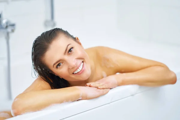 Young nice brunette woman having bath in bathtub Royalty Free Stock Photos