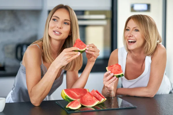Nice duas meninas adultas na cozinha com melancia — Fotografia de Stock
