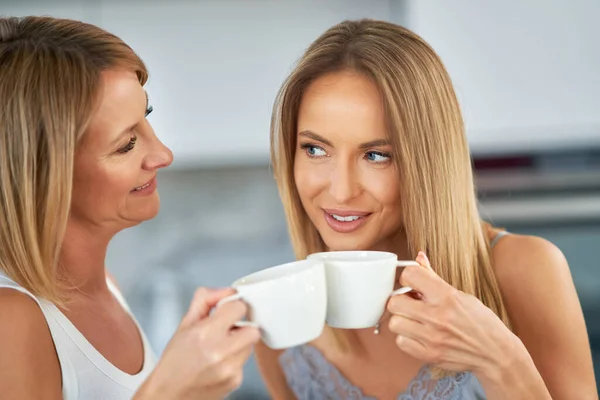 Trevliga två vuxna flickor i köket med kaffe — Stockfoto