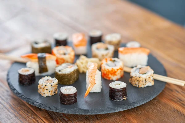 Tahta masadaki suşili taş tabak.