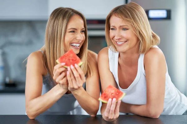 Leuke twee volwassen meisjes in de keuken met watermeloen — Stockfoto