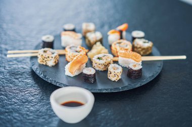 Taş tezgahın üstünde suşi olan taş tabaklar.