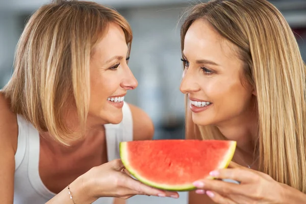 Belles deux filles adultes dans la cuisine avec pastèque — Photo