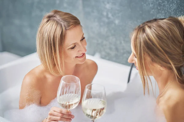 Две девушки или пара в ванной, развлекаясь — стоковое фото