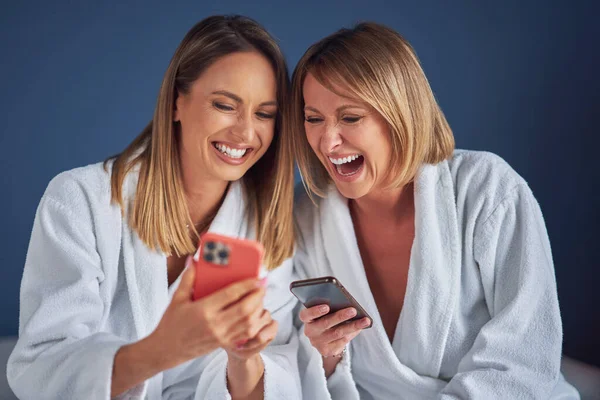 Two girls wearing bathrobe in spa or hotel having fun — Stockfoto