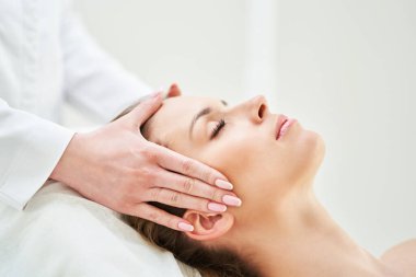 Kaplıcada yüz masajı yaptıran güzel bir kadın.