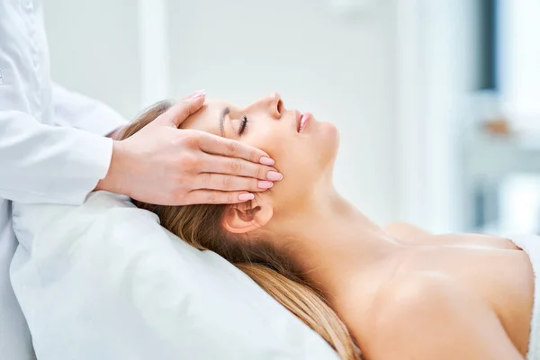 Giovane bella donna con massaggio facciale in spa — Foto Stock