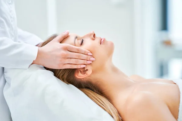 Young nice woman having face massage in spa — Fotografia de Stock