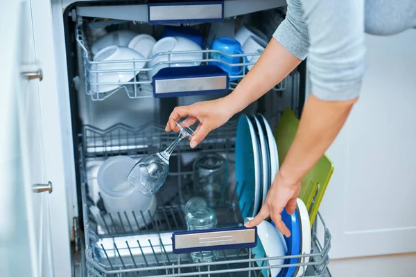 Young woman cleaning dishwasher in the kitchen. High quality photo