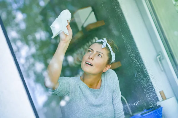 Genç bayan mutfağın penceresini temizliyor. Yüksek kalite fotoğraf