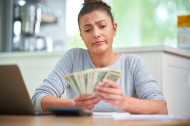Young woman counting home budget with bills. High quality photo