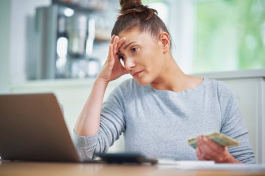 Genç bir kadın faturalarla ev bütçesini sayıyor. Yüksek kalite fotoğraf