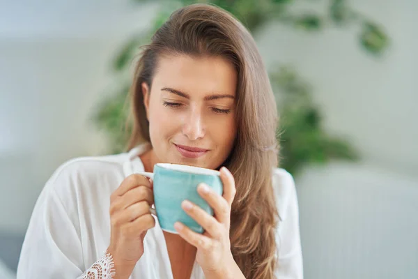 布鲁内特的女人在睡衣上涂了杯咖啡或茶 情况很糟 高质量的照片 — 图库照片