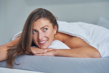 Güzel görünümlü seksi esmer yatakta dinleniyor. Yüksek kalite fotoğraf