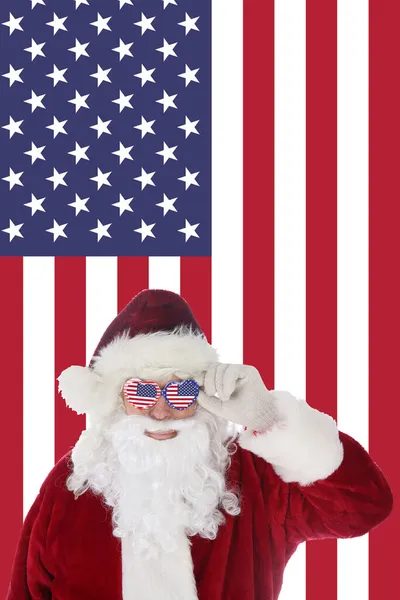 Der Weihnachtsmann Lächelt Als Seine Sonnenbrille Mit Amerikanischem Flaggenhintergrund Aufsetzt — Stockfoto