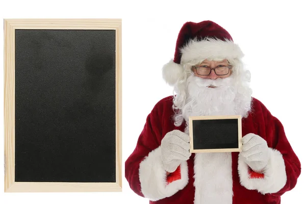 サンタクロースは空白の黒いチョークボードを保持しています テキスト用の部屋 あなたのテキストやクリスマスの願いのための部屋とサンタのブランクチョークボード 広告や願いリストやいたずらや素敵な名前のためのチョークボード サンタクロースは黒い看板を指して — ストック写真