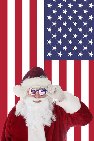 Der Weihnachtsmann Lächelt Als Seine Sonnenbrille Mit Amerikanischem Flaggenhintergrund Aufsetzt — Stockfoto