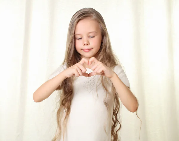 Ξανθό κοριτσάκι δείχνει καρδιά σύμβολο από τα δάχτυλα — Φωτογραφία Αρχείου