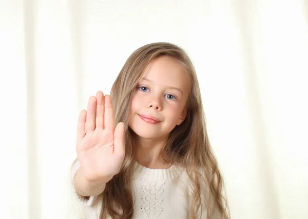 Little blond girl shows stop sign by palm an looking to camera — Stok fotoğraf