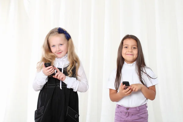 Twee kleine meisjes bellen via de telefoon — Stockfoto