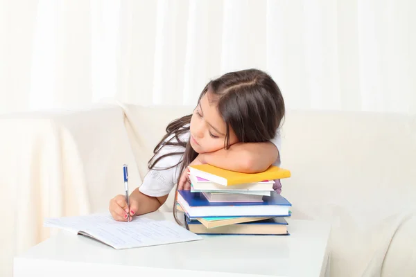 Klein meisje het lezen van een boek zittend op de Bank — Stockfoto