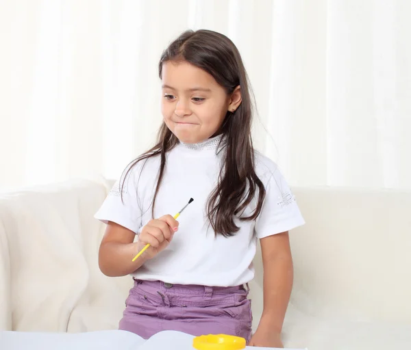 Kleines Mädchen hält einen Pinsel und beginnt zu zeichnen — Stockfoto