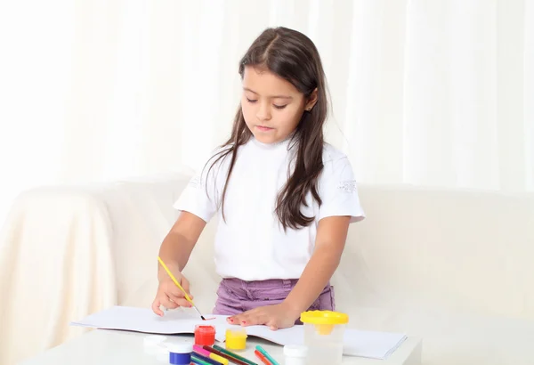 Kleines Mädchen hält einen Pinsel und beginnt zu zeichnen — Stockfoto