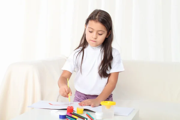 Kleines Mädchen hält einen Pinsel und beginnt zu zeichnen — Stockfoto