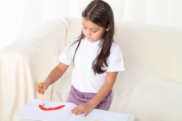 Kleines Mädchen hält einen Pinsel und beginnt zu zeichnen — Stockfoto