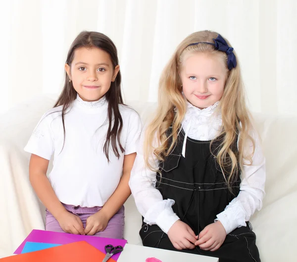 Twee kleine meisjes beeldhouwen klei op sofa in kamer — Stockfoto