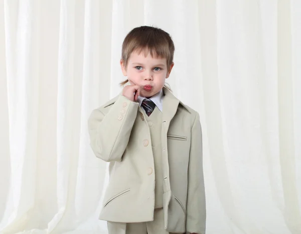 Πορτρέτο του έξυπνο μικρό ξανθό αγόρι στο κοστούμι στο σπίτι — Φωτογραφία Αρχείου