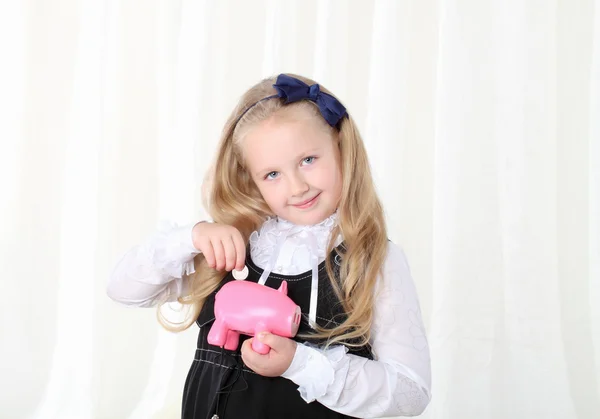 Mały dziewczyna wkłada monety do Świnka skarbonka — Zdjęcie stockowe