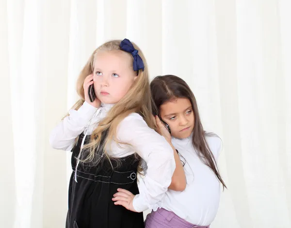 Twee kleine meisjes bellen via de telefoon — Stockfoto