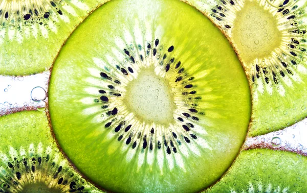 Kiwi fruit in soda water — Stock Photo, Image