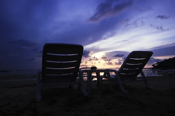 Cadeiras de praia no perfeito nascer do sol tropical Fotografia De Stock