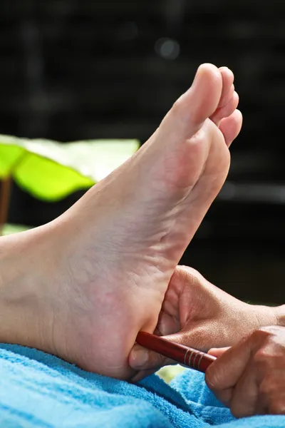 Massaggio ai piedi con bastoncino di legno per testicoli o ovaie — Foto Stock