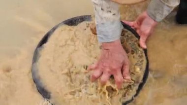 Büyük özgül yerçekimi parçacıkları (özellikle altın) topraktan ayırmak için basit bir yöntemdir.