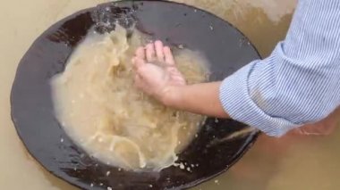 Büyük özgül yerçekimi parçacıkları (özellikle altın) topraktan ayırmak için basit bir yöntemdir.