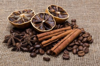 Tarçınlı kahve çubukları doğal bir arka planda kurutulmuş sitruslar.