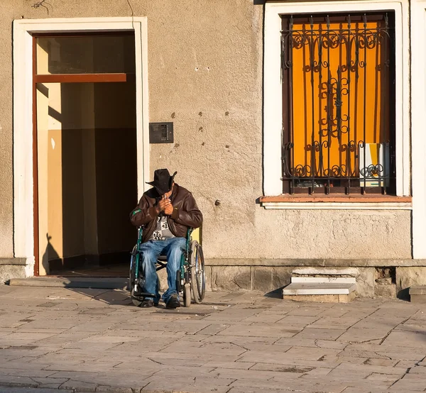 Disabled person in a wheelchair lights a cigarette — Stock Photo, Image