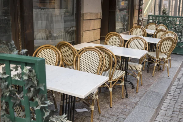 Rieten stoelen en witte tafels — Stockfoto