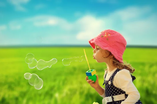 Маленька дівчинка грає з мильними бульбашками Стокове Фото