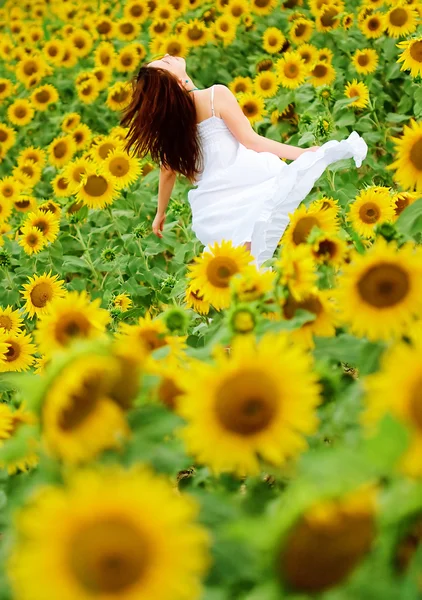 Glad tjej mellan solros — Stockfoto