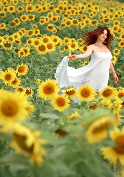 Happy girl between sunflower — Stock Photo, Image